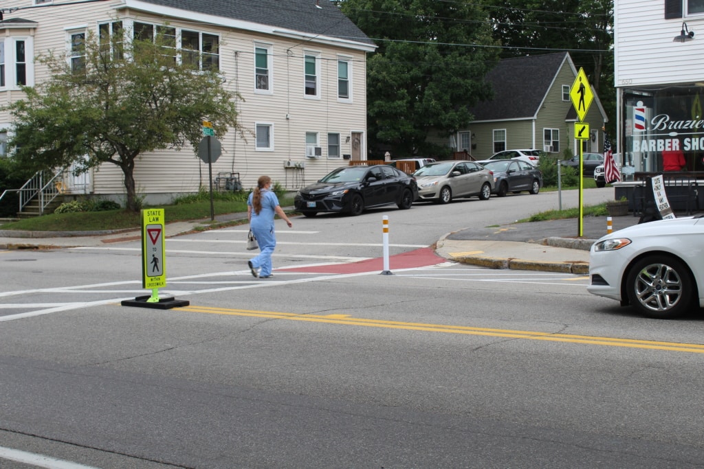 Person uses crosswalk to cross street. 